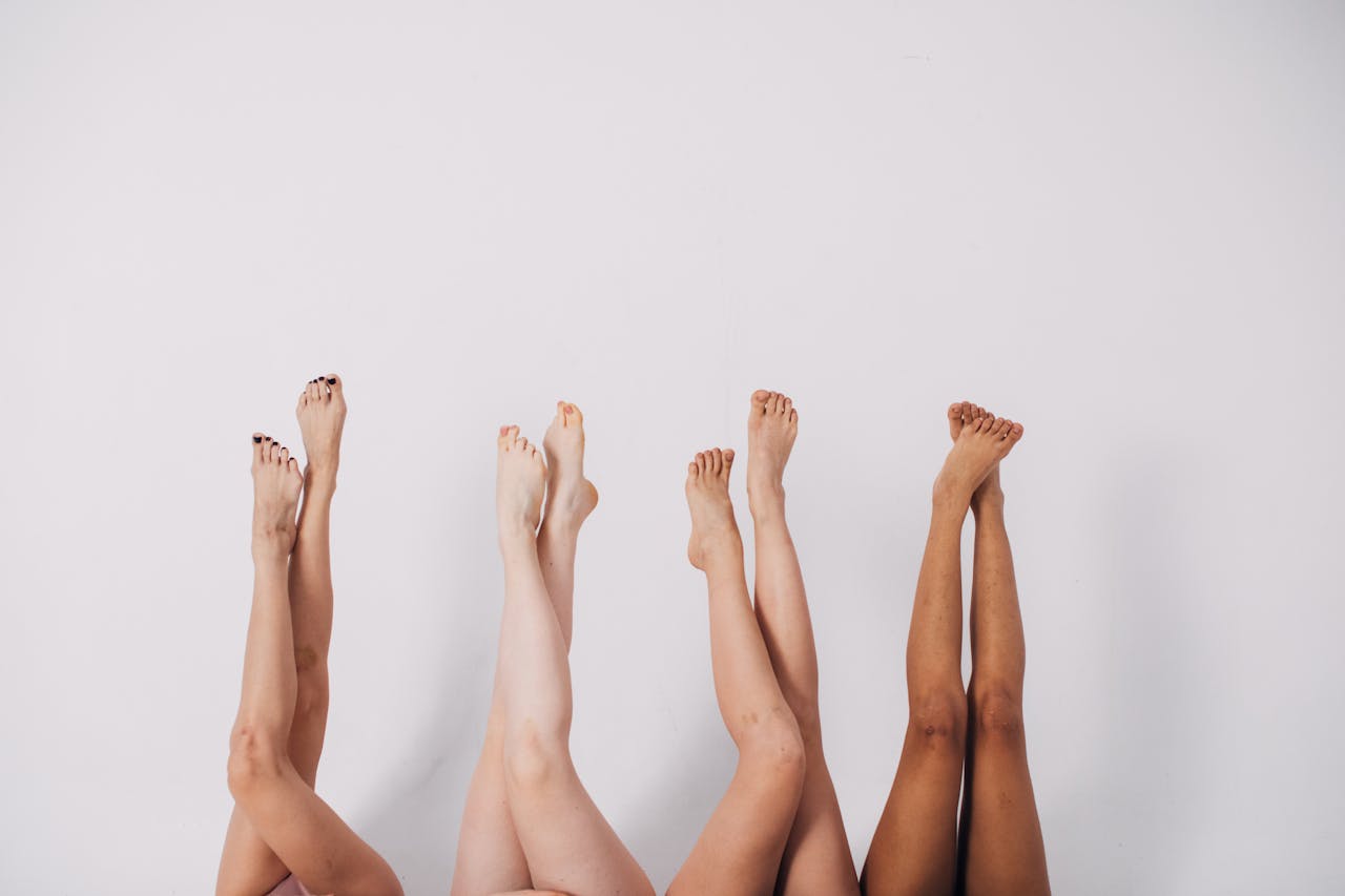 Four pairs of legs raised against a white background symbolizing diversity.